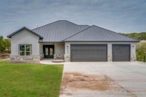 Modern house with gray metal roof and stone accents.