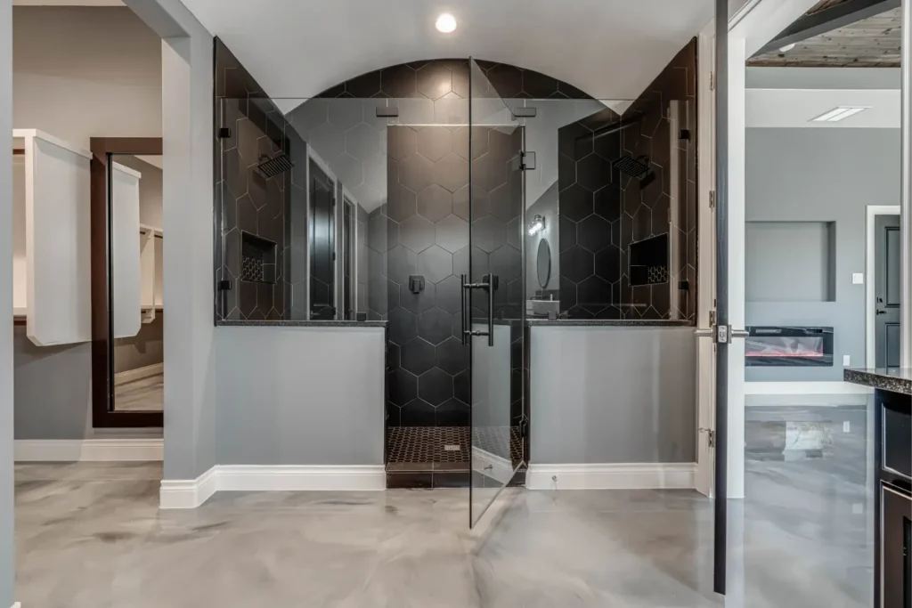 Modern shower with hexagonal tiles and glass doors.