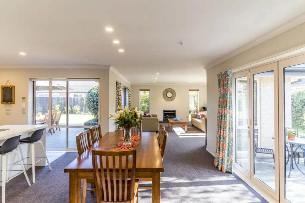 A bright, open-concept living and dining area with large windows, reflecting the trend of airy, open-plan homes.