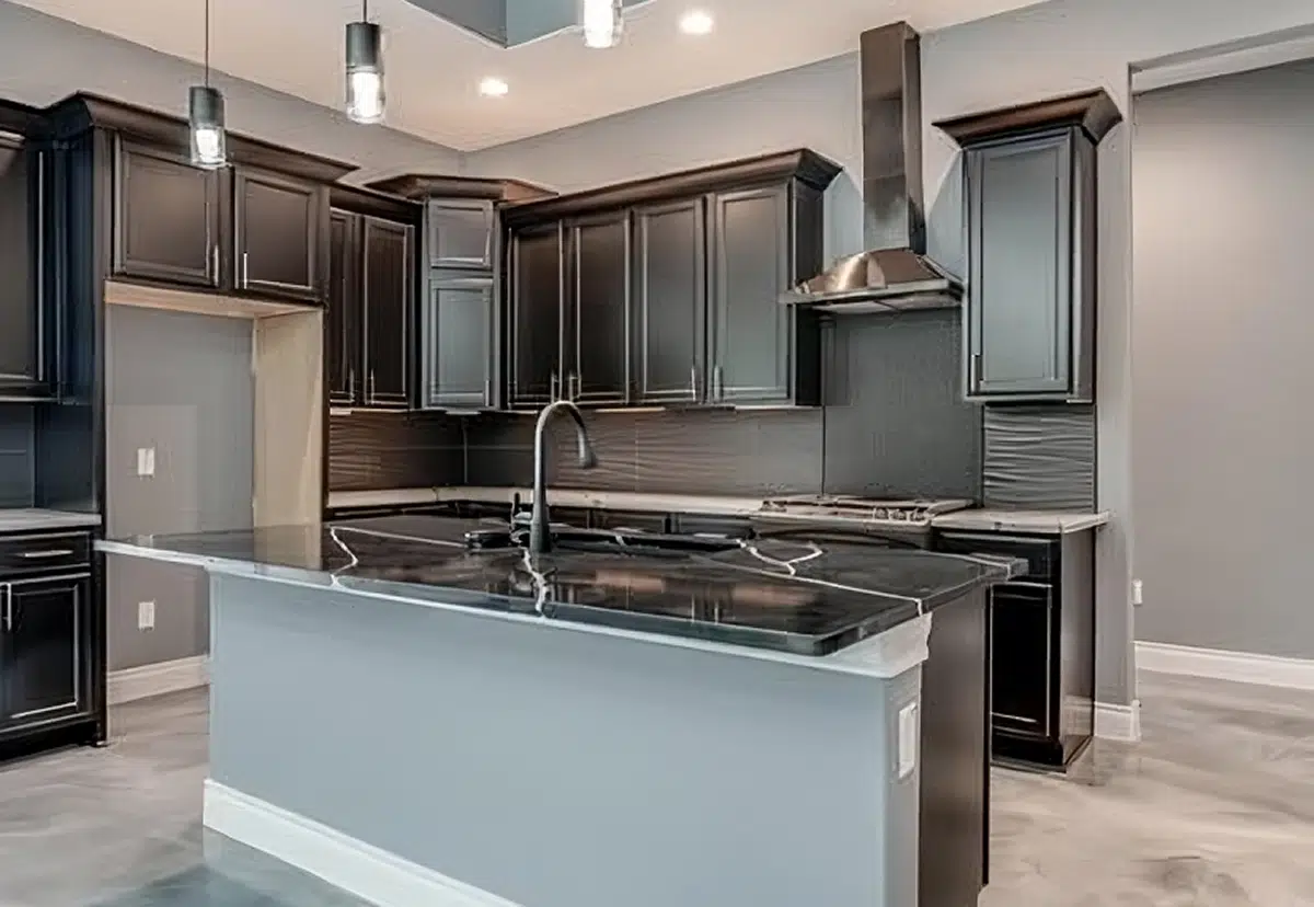 A sleek kitchen featuring black cabinetry, a glossy island, and modern lighting fixtures.