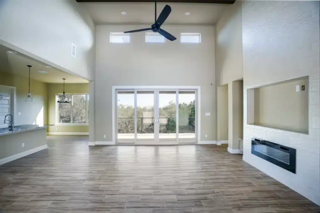 Spacious living area with high ceiling and sliding glass doors.
