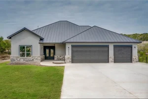 Modern house with gray metal roof and stone accents.