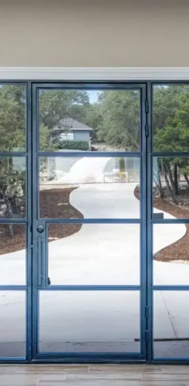 Modern Home Builder in Boerne, TX 10 Glass door with view of winding driveway and trees.