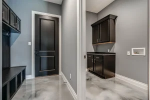 Modern mudroom with black cabinets and glossy floor.