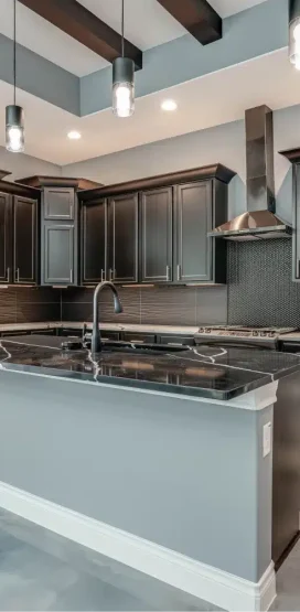 Luxury Home Builder in Boerne, TX 7 Modern kitchen with black island and fireplace.